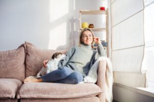 Serene woman housewife lounge sit on sofa with dog at home