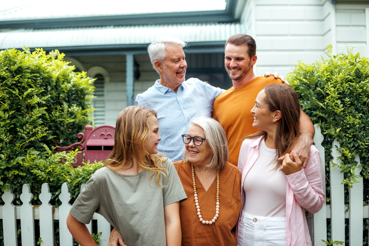 Portrait of happy multigenerational family in front of their house